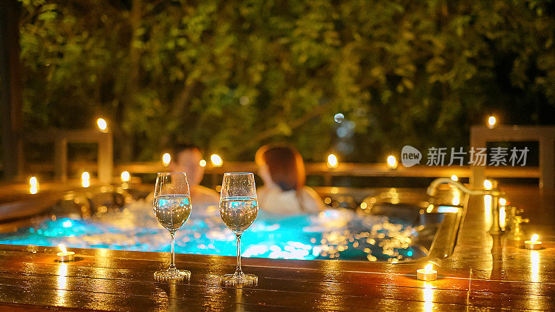 Wine glasses and couple is at hot tub bath.